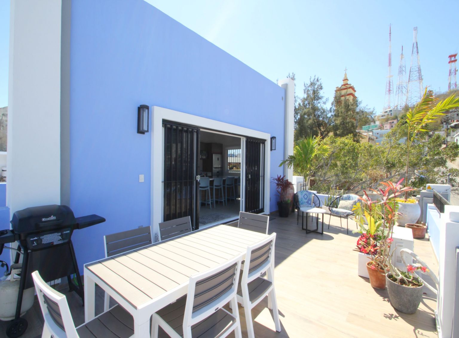 Large patio with dining table, BBQ and sitting areas.